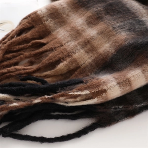 Macro detail of classic brown plaid cashmere-like scarf with soft brushed texture and tassels
