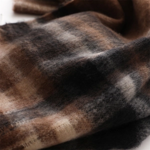 Macro detail of soft plaid scarf texture with warm brown and beige checkered patterns