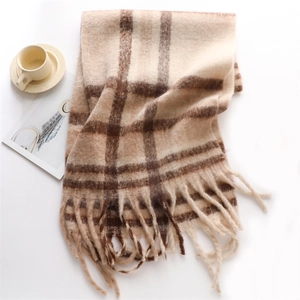 Macro detail of beige and brown checkered scarf texture with soft fringe and coffee cup