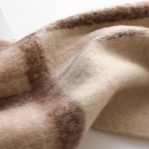 Detailed macro shot showing the soft brushed texture of the thick plaid cashmere scarf