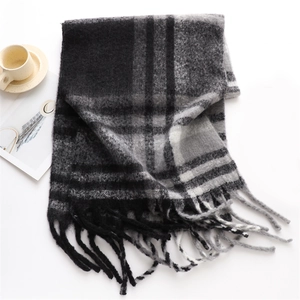 Close-up of thick plaid cashmere scarf with long tassels and monochrome check pattern