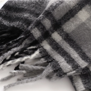Detail shot of black and grey plaid cashmere-like scarf with brushed texture and fringe