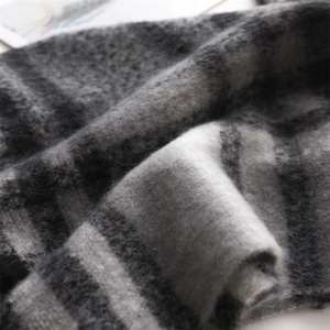 Close-up of gray plaid cashmere scarf showing thick brushed texture and soft knit fiber
