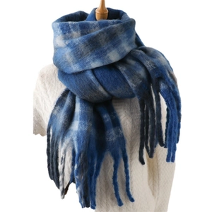 Winter blue and white plaid cashmere-like scarf with tassels on a white knit sweater