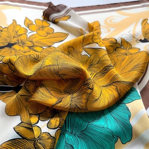 Detail of floral silk scarf with yellow peonies, blue leaves and rolled edges