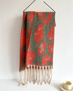 Details eines Leoparden-Strickschals mit bunten Mustern und langen beigen Fransen
