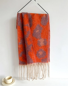 Details der Stricktextur von orange-lila Blumenschal mit cremefarbenen Fransenquasten