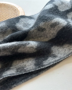Detailansicht eines dicken Schals mit Leopardenmuster und weicher Kaschmir-Textur in Grau