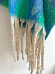 Nahaufnahme des flauschigen Mohair-Schals mit Farbverlauf und langen Fransen