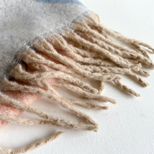 Détail d'une écharpe d'hiver épaisse avec patchwork coloré et finitions à franges
