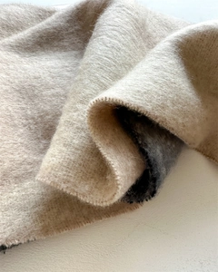 Gros plan sur l'écharpe en faux cachemire beige, texture brossée douce et détails de franges