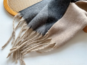 Détail d'une écharpe douce au toucher cachemire avec franges et motif bicolore
