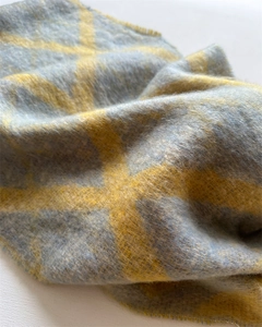 Détail de l'écharpe à carreaux bleu et jaune montrant la texture douce du mohair