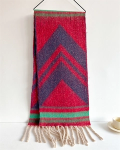 Detail of colorful geometric V-pattern knit scarf with thick cream white tassels