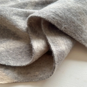 Gros plan sur la texture douce du fil bouclé d'une écharpe d'hiver gris chaud