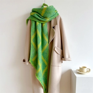 Écharpe épaisse à carreaux vert et jaune avec franges, portée sur un manteau beige