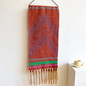 Close-up of knit scarf with colorful geometric patterns and decorative khaki tassels