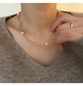 Détail d'un collier de perles françaises avec perles dorées et cristaux sur mannequin