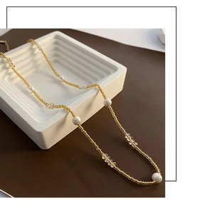Détail du collier de perles à la française avec perles dorées et cristaux facettés