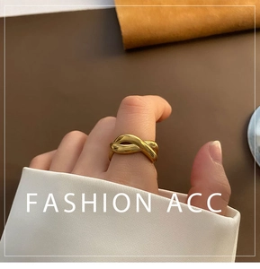 Close-up of a 18K gold-plated titanium steel twisted ring worn on a woman's finger
