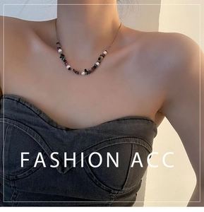 Close-up of irregular crushed stone and pearl necklace on woman neck in natural light