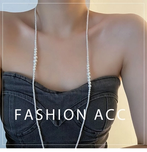 Détail d'un collier de perles multicouche avec des perles dégradées sur un haut en jean