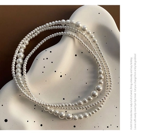 Détail macro d'un collier de perles à trois rangs avec perles dégradées sur plateau