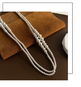 Gros plan sur le collier de perles blanches double couche au design vintage français