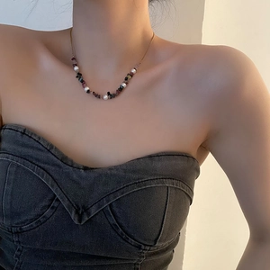 Agate gravel and pearl necklace with gold chain worn by a model on collarbone