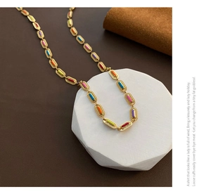 Detail of colorful enamel charms on a vintage gold plated oval link chain necklace
