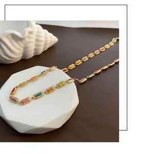 Macro detail of gold-plated rainbow enamel oval links on a stylish steel necklace