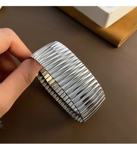 Macro view of adjustable silver titanium steel cuff bracelet with 3D pleated texture
