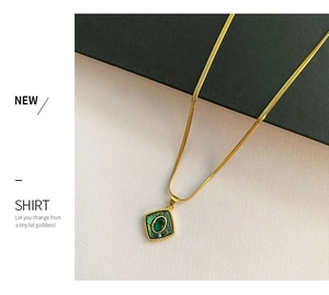 Detail of vintage gold herringbone chain with square green abalone shell pendant