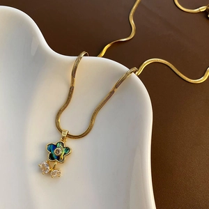 Collier fleur doré élégant avec nacre d'abalone et zircon sur un plateau en céramique