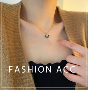 Detail of elegant gold lock pendant with iridescent shell inlay worn by a model