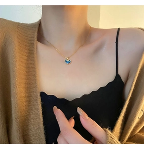 Detail of blue cat-shaped lock pendant necklace worn on neck for luxury fashion
