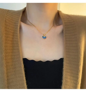 Close-up of elegant gold chain with blue ruyi lock pendant on female model