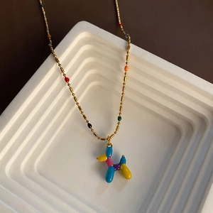 Pendentif chien ballon coloré en émail sur une chaîne à perles dorées en bleu et jaune