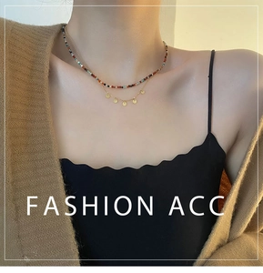 Détail d'un collier double rang avec perles colorées et cinq pendentifs ronds dorés