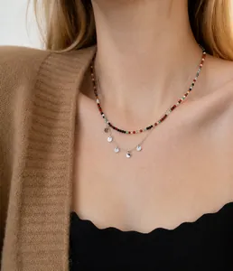 Gros plan d'un collier double épaisseur avec perles colorées et paillettes argentées