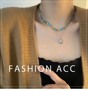 Détail du collier à deux rangs en titane avec perles en émail colorées et pendentif