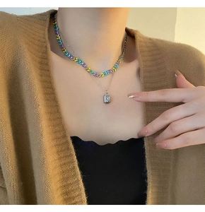 Gros plan du collier double couche en acier titane avec zircon carré et perles colorées