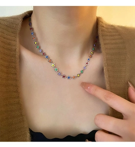 Détail du collier à pendentifs fleurs colorées en acier inoxydable argenté sur un mannequin