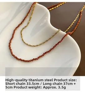 Detail view of double-layer titanium steel necklace with brown beads in a heart dish