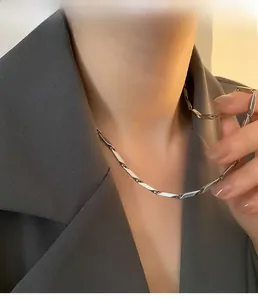 Macro detail of a silver stainless steel bamboo link chain necklace on model