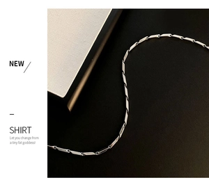 Detail of silver titanium steel necklace with geometric links on black background
