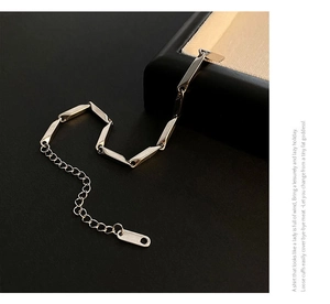 Detail of golden stainless steel link necklace with adjustable chain and logo tag