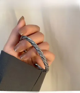 Macro shot of silver twisted metal texture on a minimalist open-ended stainless steel cuff