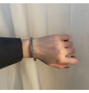 Close-up of a twisted cable bangle in retro silver finish on a model's wrist