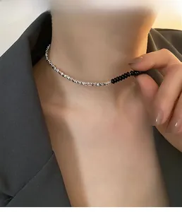 Dettaglio di girocollo in argento minimalista con perline nere su collo della modella